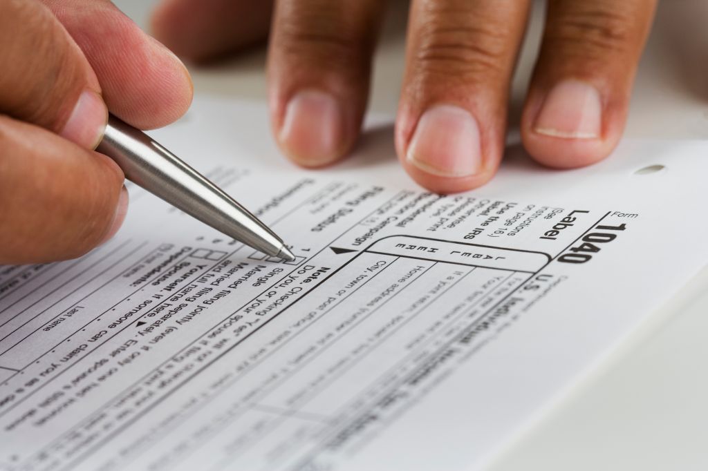 Close up of hands filling in tax form