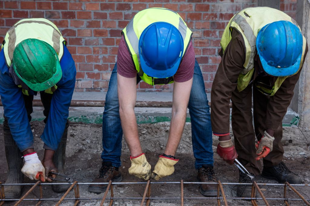 Construction workers on a construction site assembling reinforcing steel