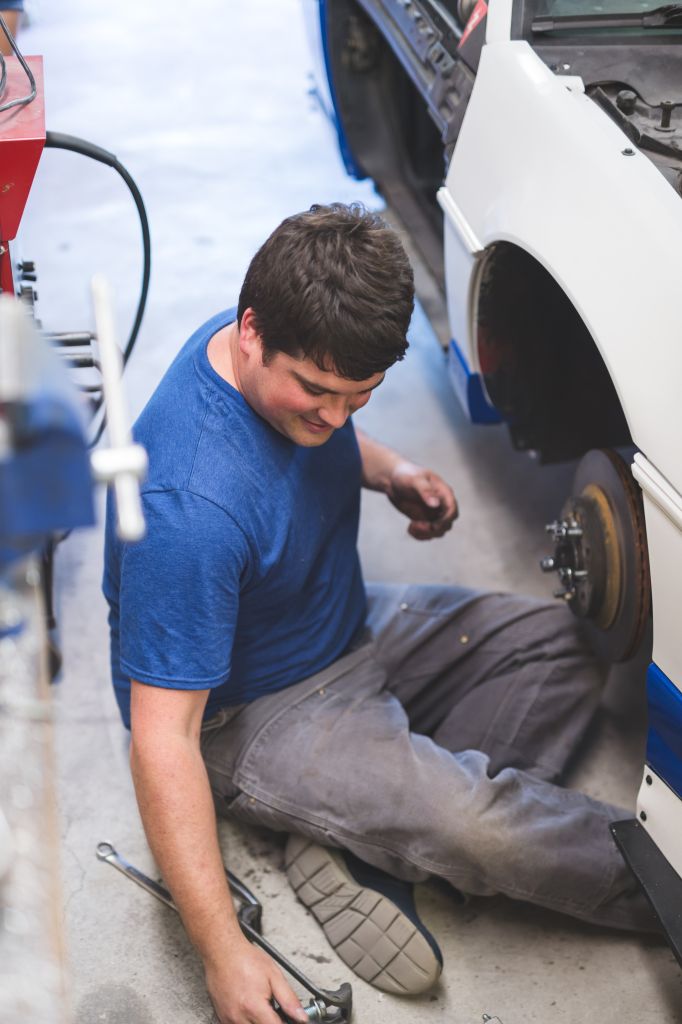 Auto Mechanic Working on Race Car in Home Garage