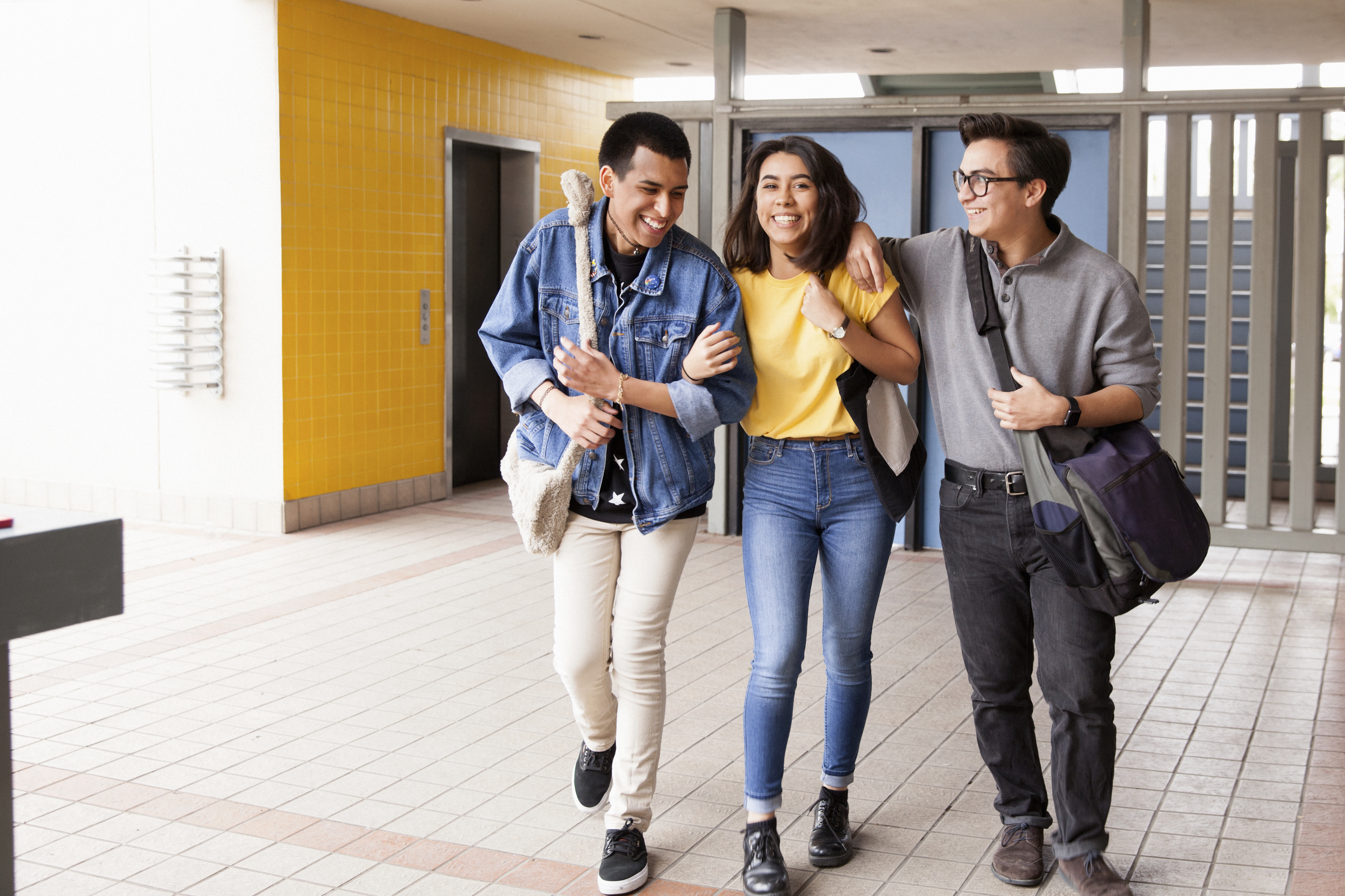 Three highschool friends walking to class.