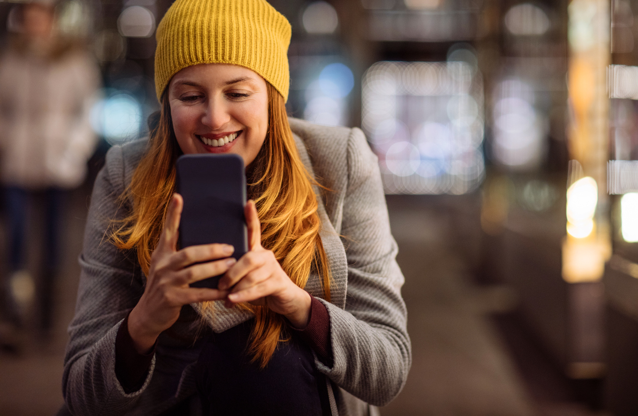 Girl looking at her phone on the street