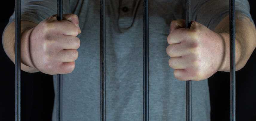 Midsection Of Prisoner Holding Bars