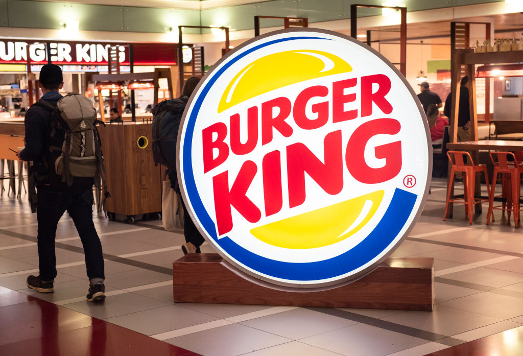 A traveller seen walking towards a fast-food hamburger...