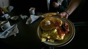 Gaby Estrella (Cq), serves Grand Slam breakfast at Denny's Restaurant in Santa Ana on the morning o