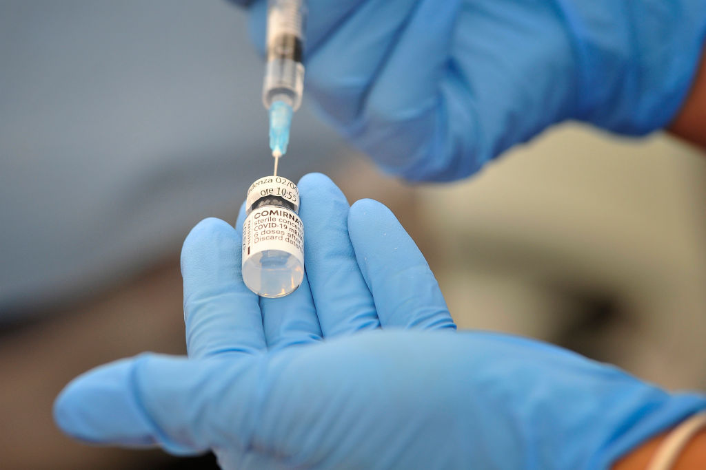 Nurse prepares a dose of Pfizer vaccine to be administered...