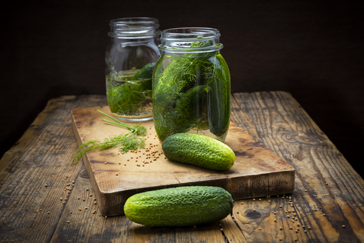 Pickled gherkins in jar with mustard seeds and dill