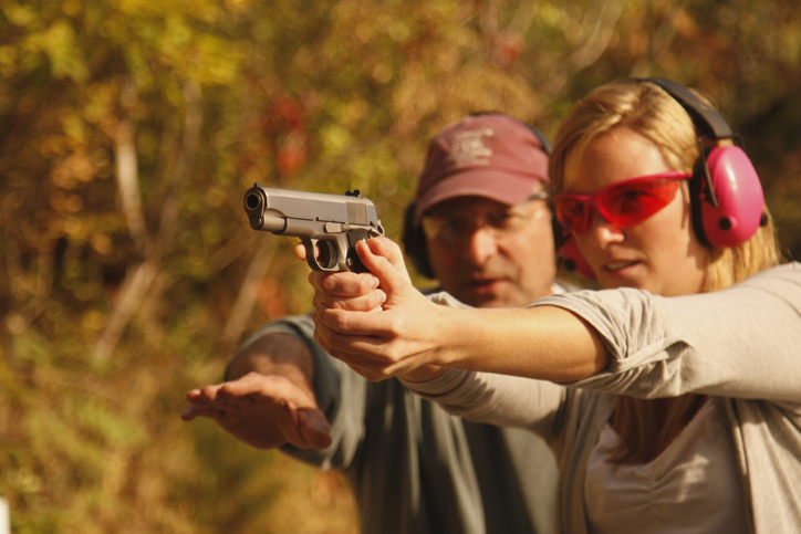 Woman Getting Instructed At Shooting Range With Handgun