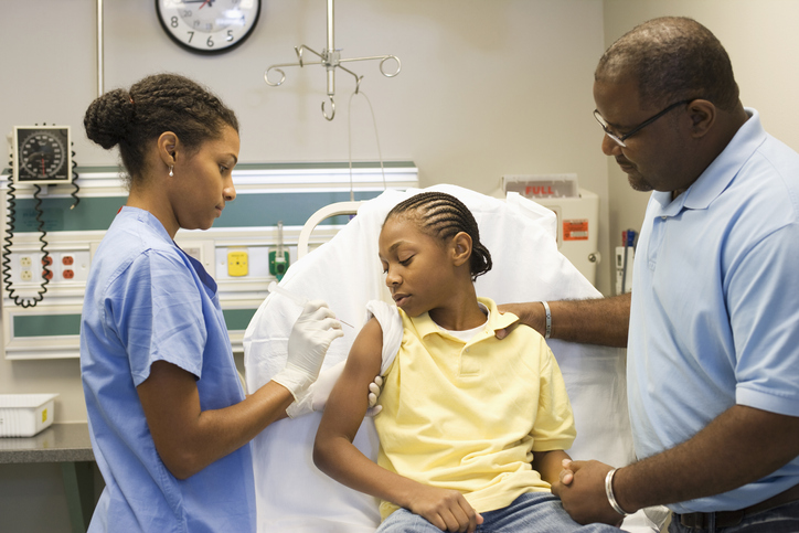 Nurse giving girl injection in hospital