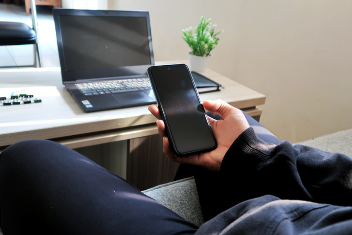 Man using mobile phone for connect to laptop in office