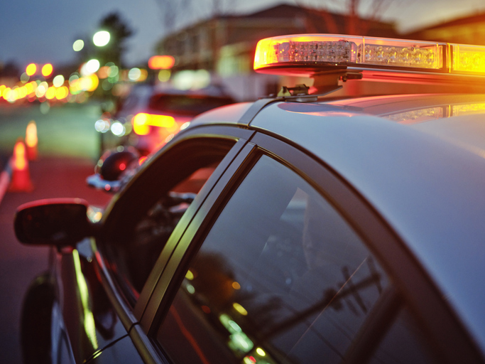 Police Car Stopped on a Road at Night with Emergency Lights