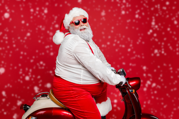 Profile side view portrait of nice bearded cheerful funny funky Santa St Nicholas father riding motor bike delivering shop orders hurry up isolated on bright vivid shine vibrant red color background