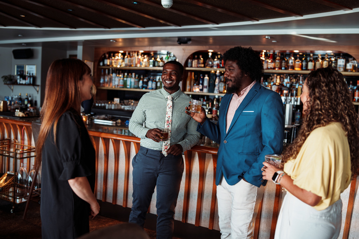 Multiracial group of friends enjoying drinks together after work