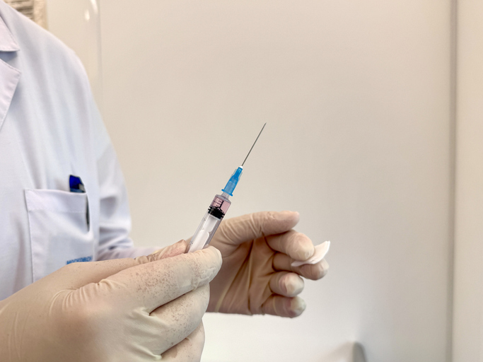 Doctor holding a syringe in a medical setting